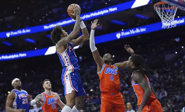 Philadelphia 76ers' Kelly Oubre Jr., left, goes up for a shot against Oklahoma City Thunder's Jalen Williams during the first half of an NBA basketball game, Tuesday, Jan. 14, 2025, in Philadelphia. (AP Photo/Matt Slocum)