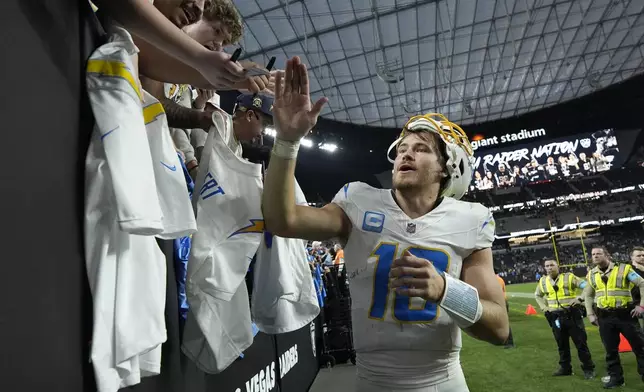 Los Angeles Chargers quarterback Justin Herbert celebrates with fans after an NFL football game against the Las Vegas Raiders in Las Vegas, Sunday, Jan. 5, 2025. (AP Photo/John Locher)