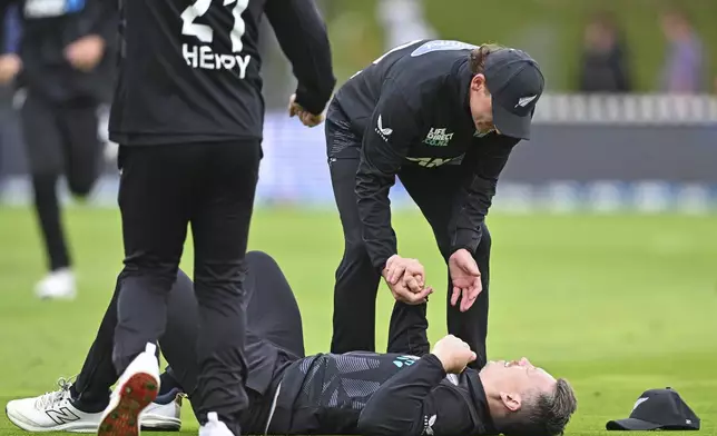 New Zealand's Nathan Smith checks on Michael Bracewell after he hits his head taking a catch to dismiss Sri Lanka's Janith Liyanage during the first ODI international cricket match between New Zealand and Sri Lanka at the Basin Reserve in Wellington, New Zealand Sunday, Jan. 5, 2025. (Kerry Marshall/Photosport via AP)