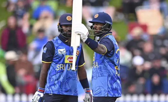 Sri Lanka's Avishka Fernando, right, celebrates after scoring 50 runs during the first ODI international cricket match between New Zealand and Sri Lanka at the Basin Reserve in Wellington, New Zealand, Sunday, Jan. 5, 2025. (Kerry Marshall/Photosport via AP)