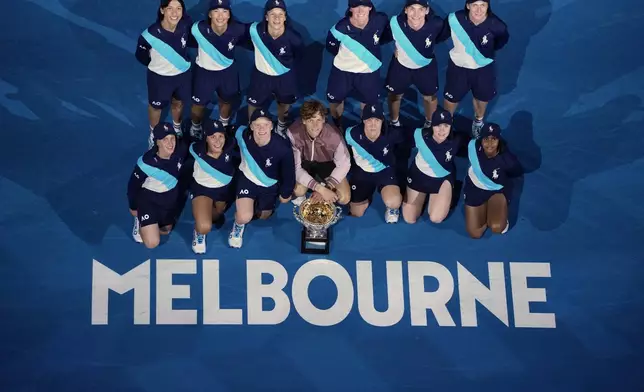 FILE - Jannik Sinner of Italy poses with ball kids and the Norman Brookes Challenge Cup after defeating Daniil Medvedev of Russia in the men's singles final at the Australian Open tennis championships at Melbourne Park, in Melbourne, Australia, Jan. 28, 2024. (AP Photo/Louise Delmotte, File)