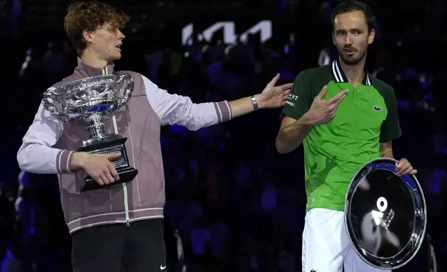 FILE - Jannik Sinner, left, of Italy gestures as he holds the Norman Brookes Challenge Cup after defeating Daniil Medvedev, right, of Russia in the men's singles final at the Australian Open tennis championships at Melbourne Park, in Melbourne, Australia, Jan. 28, 2024. (AP Photo/Andy Wong, File)