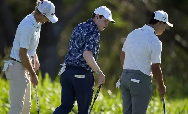 From left; Will Zalatoris, Robert MacIntyre, of Scotland, and Si Woo Kim, of South Korea, walks across the fourth green during the first round of The Sentry golf event, Thursday, Jan. 2, 2025, at Kapalua Plantation Course in Kapalua, Hawaii. (AP Photo/Matt York)