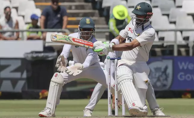 Pakistan's Shan Masood plays a shot while South Africa's Kyle Verreynne looks on during the fourth day of the second test match between South Africa and Pakistan in Cape Town, South Africa, Monday, Jan. 6, 2025. (AP Photo/Halden Krog)