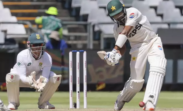 Pakistan's Khurram Shahzad plays a shot while South Africa's Kyle Verreynne looks on during the fourth day of the second test match between South Africa and Pakistan in Cape Town, South Africa, Monday, Jan. 6, 2025. (AP Photo/Halden Krog)