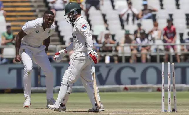 South Africa's Kagiso Rabada, left, celebrates the wicket of Pakistan's Kamran Ghulam during the fourth day of the second test match between South Africa and Pakistan in Cape Town, South Africa, Monday, Jan. 6, 2025. (AP Photo/Halden Krog)