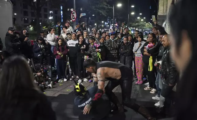 Neighbors watch Lucha Libre wrestlers perform, arranged by volunteers who call themselves the Punk Kings as they distribute toys, clothes and pinatas to underprivileged children on the occasion of the Epiphany, or Three Kings Day, in Mexico City, Sunday, Jan. 5, 2025. (AP Photo/Eduardo Verdugo)