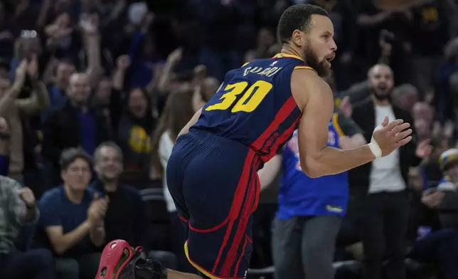 Golden State Warriors guard Stephen Curry reacts after scoring against the Miami Heat during the second half of an NBA basketball game Tuesday, Jan. 7, 2025, in San Francisco. (AP Photo/Godofredo A. Vásquez)