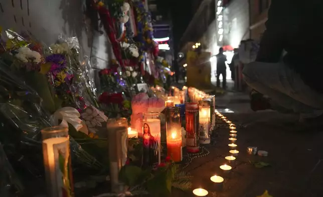 Flowers and votive candles line a memorial for the victims of a deadly truck attack on New Year's Day in New Orleans, Friday, Jan. 3, 2025. (AP Photo/Gerald Herbert)