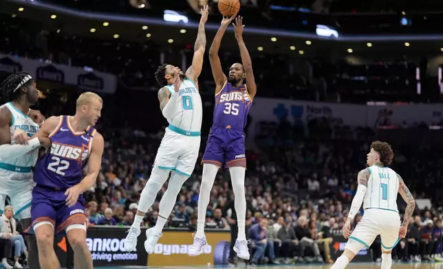 Phoenix Suns forward Kevin Durant (35) shoots a jump shot over Charlotte Hornets forward Miles Bridges (0) during the first half of an NBA basketball game in Charlotte, N.C., Tuesday, Jan. 7, 2025. (AP Photo/Jim Dedmon)