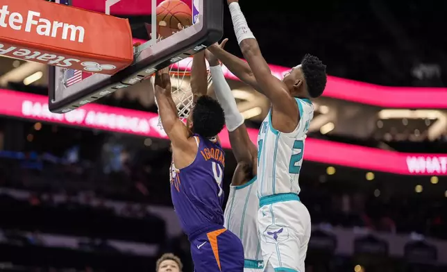 Charlotte Hornets forward Brandon Miller blocks a shot by Phoenix Suns center Oso Ighodaro during the first half of an NBA basketball game in Charlotte, N.C., Tuesday, Jan. 7, 2025. (AP Photo/Jim Dedmon)