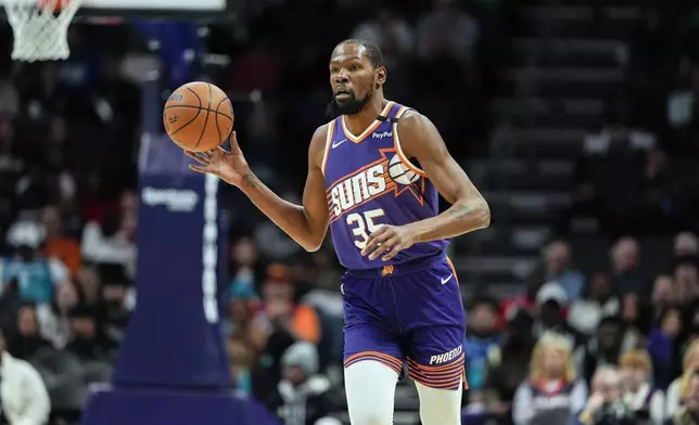 Phoenix Suns forward Kevin Durant (35) brings the ball up court against the Charlotte Hornets during the first half of an NBA basketball game in Charlotte, N.C., Tuesday, Jan. 7, 2025. (AP Photo/Jim Dedmon)