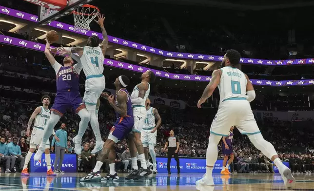 Charlotte Hornets center Nick Richards (4) tries to block a shot by Phoenix Suns center Jusuf Nurkic (20) during the first half of an NBA basketball game in Charlotte, N.C., Tuesday, Jan. 7, 2025. (AP Photo/Jim Dedmon)