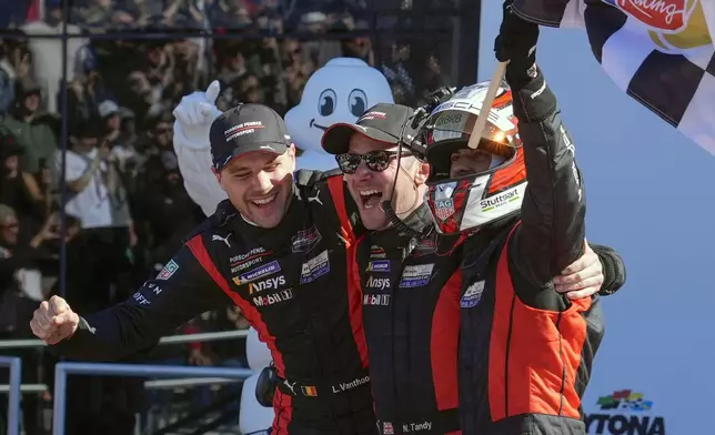 Porsche Penske Motorsports team members, from left to right, Belgium's Laurens Vanthoor, Britain's Nick Tandy and Brazil's Felipe Nasr celebrate in Victory Lane after winning the IMSA Rolex 24 hour auto race at Daytona International Speedway, Sunday, Jan. 26, 2025, in Daytona Beach, Fla. (AP Photo/John Raoux)