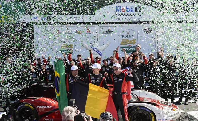 Porsche Penske Motorsport team drivers, from left to right, Brazil's Felipe Nasr, Belgium's Laurens Vanthoor and Britain's Nick Tandy celebrate in Victory Lane after winning the IMSA Rolex 24 hour auto race at Daytona International Speedway, Sunday, Jan. 26, 2025, in Daytona Beach, Fla. (AP Photo/John Raoux)