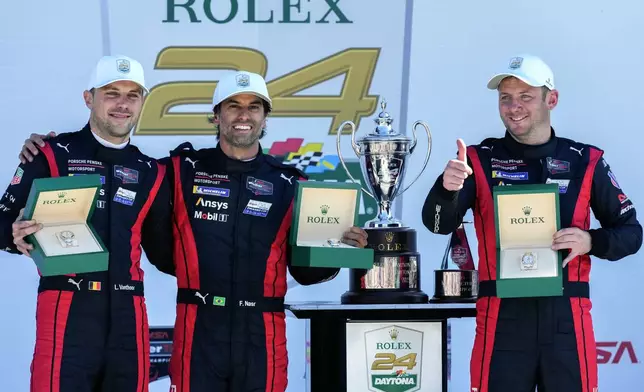 Porsche Penske Motorsport team members, from left to right, Belgium's Laurens Vanthoor, Brazil's Felipe Nasr and Britain's Nick Tandy display their Rolex watches they received after winning the IMSA Rolex 24 hour auto race at Daytona International Speedway, Sunday, Jan. 26, 2025, in Daytona Beach, Fla. (AP Photo/John Raoux)