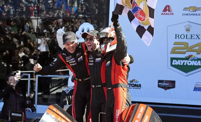 Porsche Penske Motorsports team members, from left to right, Belgium's Laurens Vanthoor, Britain's Nick Tandy and Brazil's Felipe Nasr celebrate in Victory Lane after winning the IMSA Rolex 24 hour auto race at Daytona International Speedway, Sunday, Jan. 26, 2025, in Daytona Beach, Fla. (AP Photo/John Raoux)