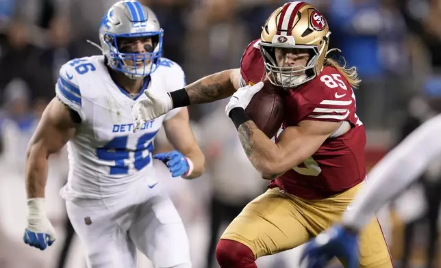 San Francisco 49ers tight end George Kittle (85) runs past Detroit Lions linebacker Jack Campbell (46) after a catch during the first half of an NFL football game Monday, Dec. 30, 2024, in Santa Clara, Calif. (AP Photo/Godofredo A. Vásquez)