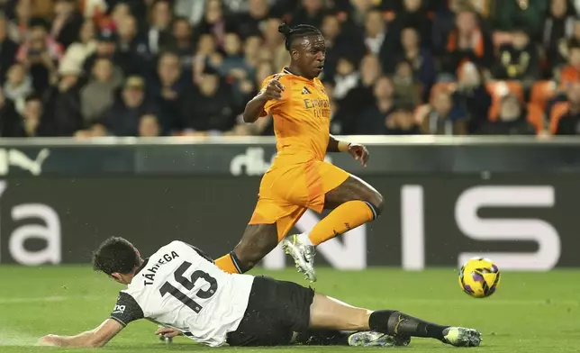 Real Madrid's Vinicius Junior, top, and Valencia's Cesar Tarrega fight for the ball during a Spanish La Liga soccer match at Mestalla stadium in Valencia, Spain, Friday, Jan. 3, 2025. (AP Photo/Alberto Saiz)