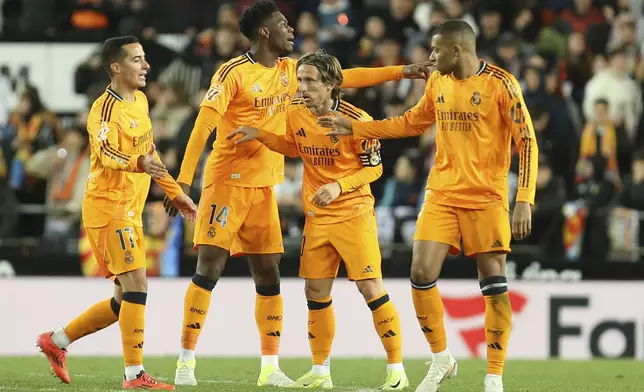 Real Madrid's Luka Modric, center, celebrates with teammates after scoring his side's first goal against Valencia during a Spanish La Liga soccer match at Mestalla stadium in Valencia, Spain, Friday, Jan. 3, 2025. (AP Photo/Alberto Saiz)