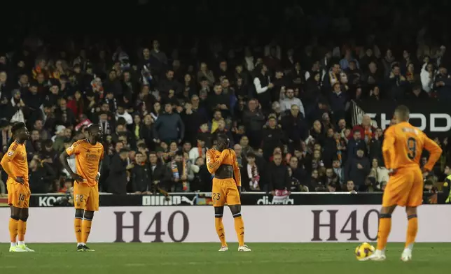 Players of Real Madrid react after Valencia's Hugo Duro scored his side's first goal during a Spanish La Liga soccer match at Mestalla stadium in Valencia, Spain, Friday, Jan. 3, 2025. (AP Photo/Alberto Saiz)