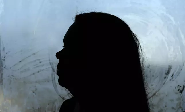 Roselins Sequera looks out the front door of her home, Monday, Dec. 9, 2024, in Marshalltown, Iowa. (AP Photo/Charlie Neibergall)