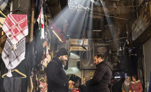 Shop owners talk while they wait for clients in Al-Hamidiyeh Souq on New Years Eve, in Damascus, Syria, Tuesday, Dec. 31, 2024. (AP Photo/Mosa'ab Elshamy)