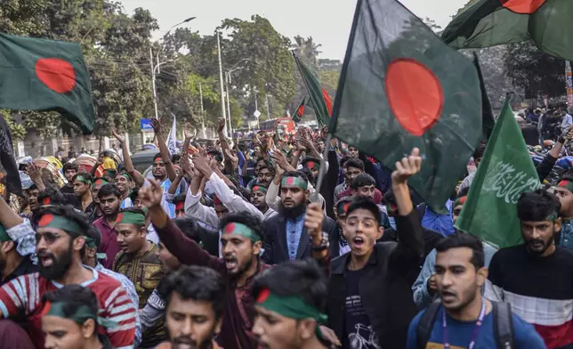 Participants, mostly students, shout slogans and wave Bangladesh national flags during "March for Unity" organized by The Anti-Discrimination Student Movement at the Central Shaheed Minar, a national monument, in Dhaka, Bangladesh, Tuesday, Dec. 31, 2024. (AP Photo/Mahmud Hossain Opu)