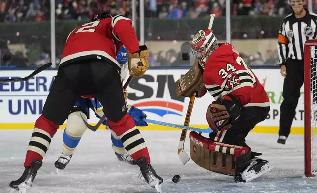 Chicago Blackhawks goaltender Petr Mrazek (34) makes a save against the St. Louis Blues during the second period of the NHL Winter Classic outdoor hockey game at Wrigley Field, Tuesday, Dec. 31, 2024, in Chicago. (AP Photo/Erin Hooley)