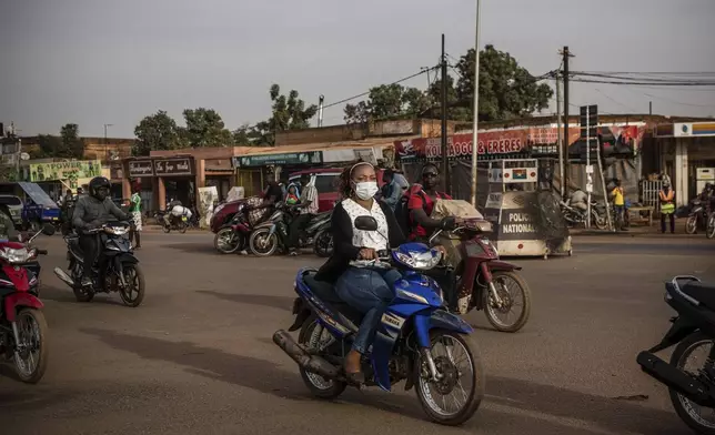 FILE - People ride their scooters in the Gounghin district of Ouagadougou, Burkina Faso, Jan. 26, 2022. (AP Photo/Sophie Garcia, File)