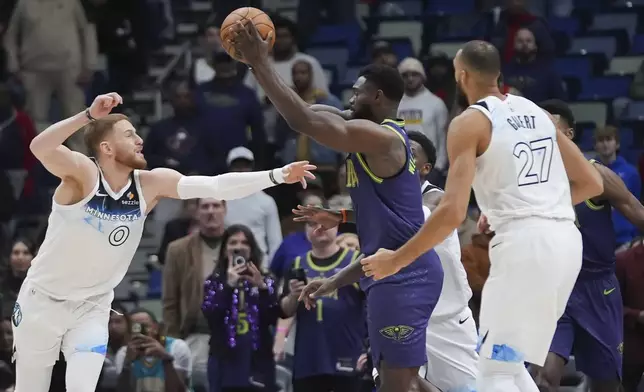 New Orleans Pelicans forward Zion Williamson moves the ball around Minnesota Timberwolves guard Donte DiVincenzo (0) in the first half of an NBA basketball game in New Orleans, Tuesday, Jan. 7, 2025. (AP Photo/Gerald Herbert)