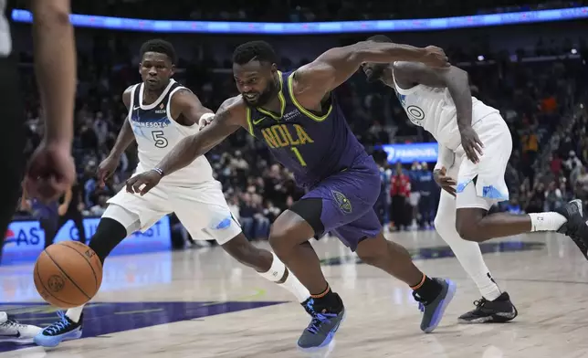 New Orleans Pelicans forward Zion Williamson (1) drives to the basket ahead of Minnesota Timberwolves guard Anthony Edwards (5) and forward Julius Randle (30) in the second half of an NBA basketball game in New Orleans, Tuesday, Jan. 7, 2025. The Timberwolves won 104-97 (AP Photo/Gerald Herbert)