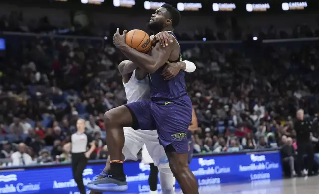 New Orleans Pelicans forward Zion Williamson is fouled by Minnesota Timberwolves forward Jaden McDaniels as he drives to the basket in the second half of an NBA basketball game in New Orleans, Tuesday, Jan. 7, 2025. The Timberwolves won 104-97. (AP Photo/Gerald Herbert)