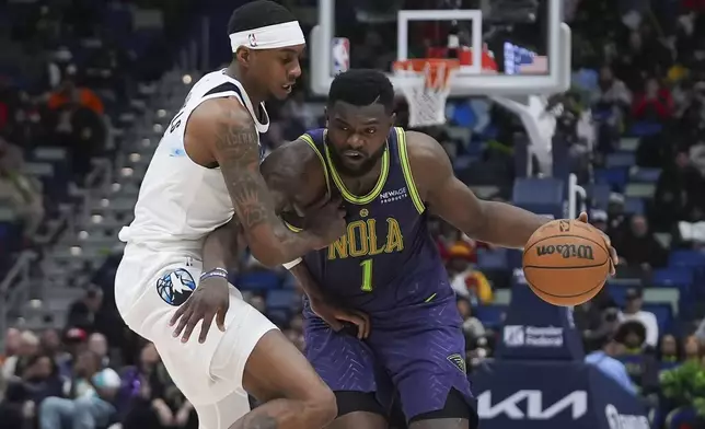 New Orleans Pelicans forward Zion Williamson (1) moves the ball against Minnesota Timberwolves forward Jaden McDaniels in the second half of an NBA basketball game in New Orleans, Tuesday, Jan. 7, 2025. The Timberwolves won 104-97. (AP Photo/Gerald Herbert)