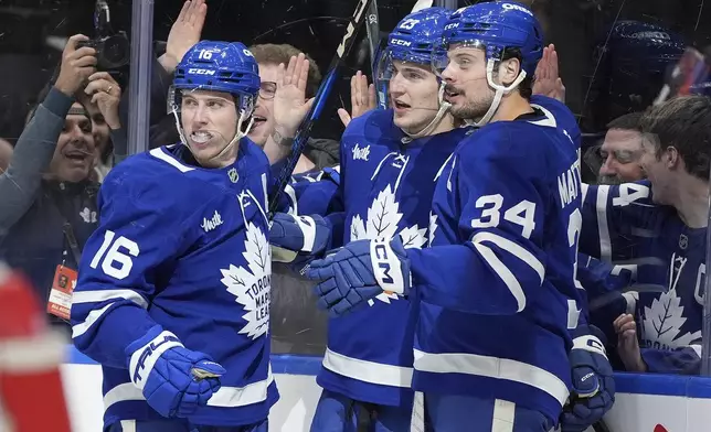 Toronto Maple Leafs left wing Matthew Knies (23) celebrates his goal with teammates Mitch Marner (16) and Auston Matthews (34) during the second period of an NHL hockey game against the Boston Bruins in Toronto, Saturday, Jan. 4, 2025. (Frank Gunn/The Canadian Press via AP)