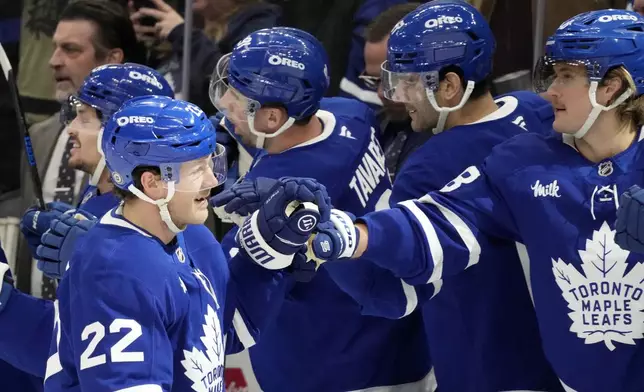 Toronto Maple Leafs defenseman Jake McCabe (22) celebrates his goal with teammates on the bench during the first period of an NHL hockey game against the Boston Bruins in Toronto, Saturday, Jan. 4, 2025. (Frank Gunn/The Canadian Press via AP)