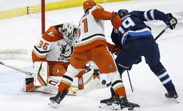 Anaheim Ducks goaltender John Gibson (36) saves the shot from Winnipeg Jets David Gustafsson (19) as Olen Zellweger (51) defends during the first period of an NHL game in Winnipeg, Manitoba, Thursday, Jan. 2, 2025. (John Woods/The Canadian Press via AP)