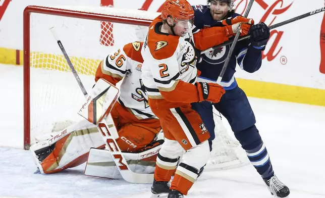 Anaheim Ducks' Jackson LaCombe (2) defends against Winnipeg Jets' Adam Lowry (17) in front of goaltender John Gibson (36) during the second period of an NHL game in Winnipeg, Manitoba, Thursday, Jan. 2, 2025. (John Woods/The Canadian Press via AP)