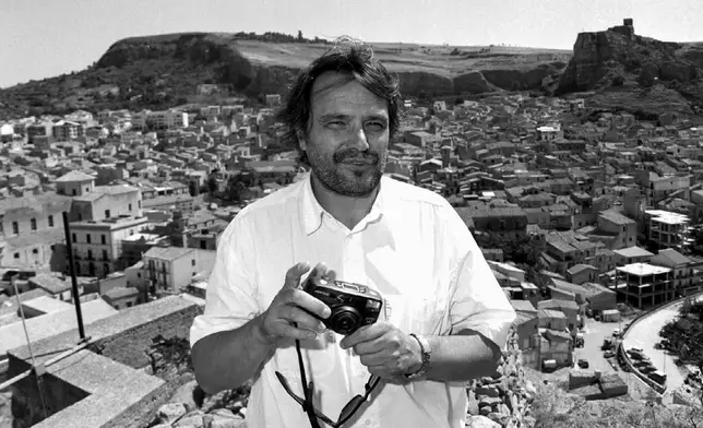 Italian photographer Oliviero Toscani holds his camera while in Corleone, Sicily island, southern Italy, on July 2, 1996. (AP Photo/Alessandro Fucarini, File)