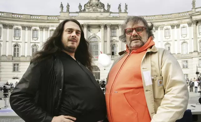 FILE - German artist Jonathan Meese, left, and Italian photographer Oliviero Toscani, pose during the "Table of the Free Voices" event in Berlin, Saturday, Sept. 9, 2006. (AP Photo/Jan Bauer, File)
