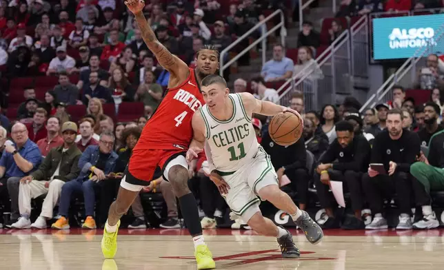 Boston Celtics' Payton Pritchard (11) drives around Houston Rockets' Jalen Green (4) during the first half of an NBA basketball game Friday, Jan. 3, 2025, in Houston. (AP Photo/David J. Phillip)