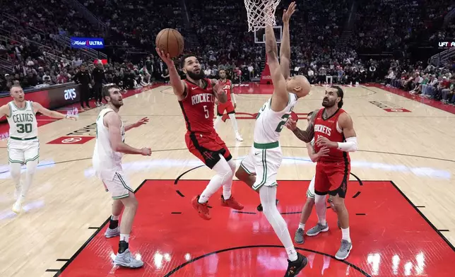 Houston Rockets' Fred VanVleet (5) goes up for a shot as Boston Celtics' Jordan Walsh, right, defends during the first half of an NBA basketball game Friday, Jan. 3, 2025, in Houston. (AP Photo/David J. Phillip)