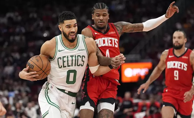 Boston Celtics' Jayson Tatum (0) drives toward the basket as Houston Rockets' Jalen Green (4) defends during the first half of an NBA basketball game Friday, Jan. 3, 2025, in Houston. (AP Photo/David J. Phillip)