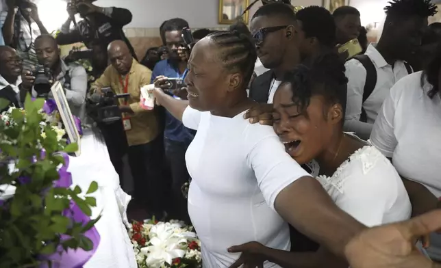 Relatives cry by the coffin of journalist Jimmy Jean, who was killed during an armed gang attack on the General Hospital, during his church funeral service in the Petion-Ville neighborhood of Port-au-Prince, Haiti, Jan. 16, 2025. (AP Photo/Odelyn Joseph)