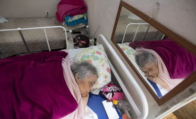 Solange Vieira Braga, who is temporarily bedridden with a broken leg, gets rest in her home in the Santa Luzia community, where residents have been ordered by the municipal government to vacate, in Rio de Janeiro, Thursday, Jan. 16, 2025. (AP Photo/Bruna Prado)