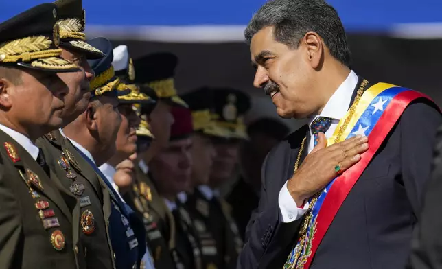 Venezuelan President Nicolas Maduro talks to high-ranking officers during a military ceremony on his inauguration day for a third term in Caracas, Venezuela, Jan. 10, 2025. (AP Photo/Ariana Cubillos)