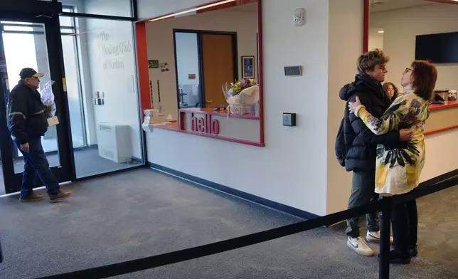 Two members of The Skating Club of Boston community embrace as flowers with condolences are delivered at the club, Thursday, Jan. 30, 2025, in Norwood, Mass. (AP Photo/Charles Krupa)