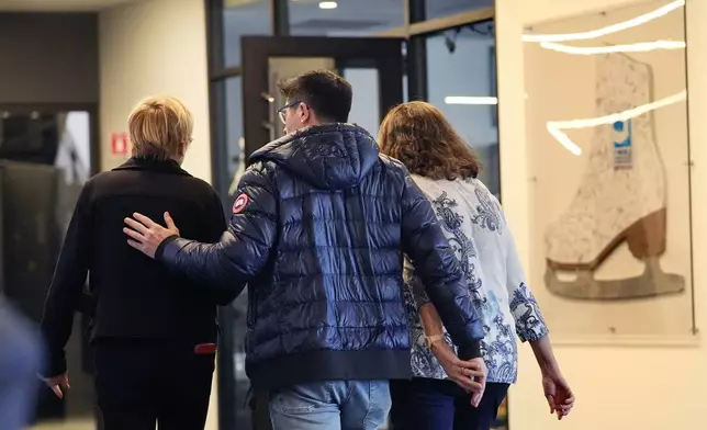 People associated with The Skating Club of Boston console each other, Thursday, Jan. 30, 2025, in Norwood, Mass. (AP Photo/Robert F. Bukaty)