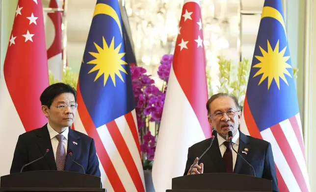 Malaysian Prime Minister Anwar Ibrahim, right, speaks during a press conference with Singapore Prime Minister Lawrence Wong at the prime minister's office in Putrajaya, Malaysia, Tuesday, Jan. 7, 2025. (AP Photo/Vincent Thian, Pool)