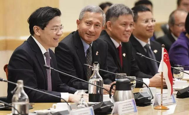 Singapore Prime Minister Lawrence Wong, left, with his delegation members meets with Malaysian Prime Minister Anwar Ibrahim, unseen, at the prime minister's office in Putrajaya, Malaysia, Tuesday, Jan. 7, 2025. (AP Photo/Vincent Thian, Pool)